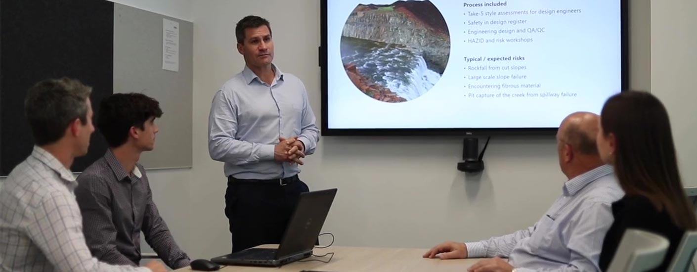 Five people from the Advisian Water Resources team sitting at a boardroom table looking at a presentation on screen.